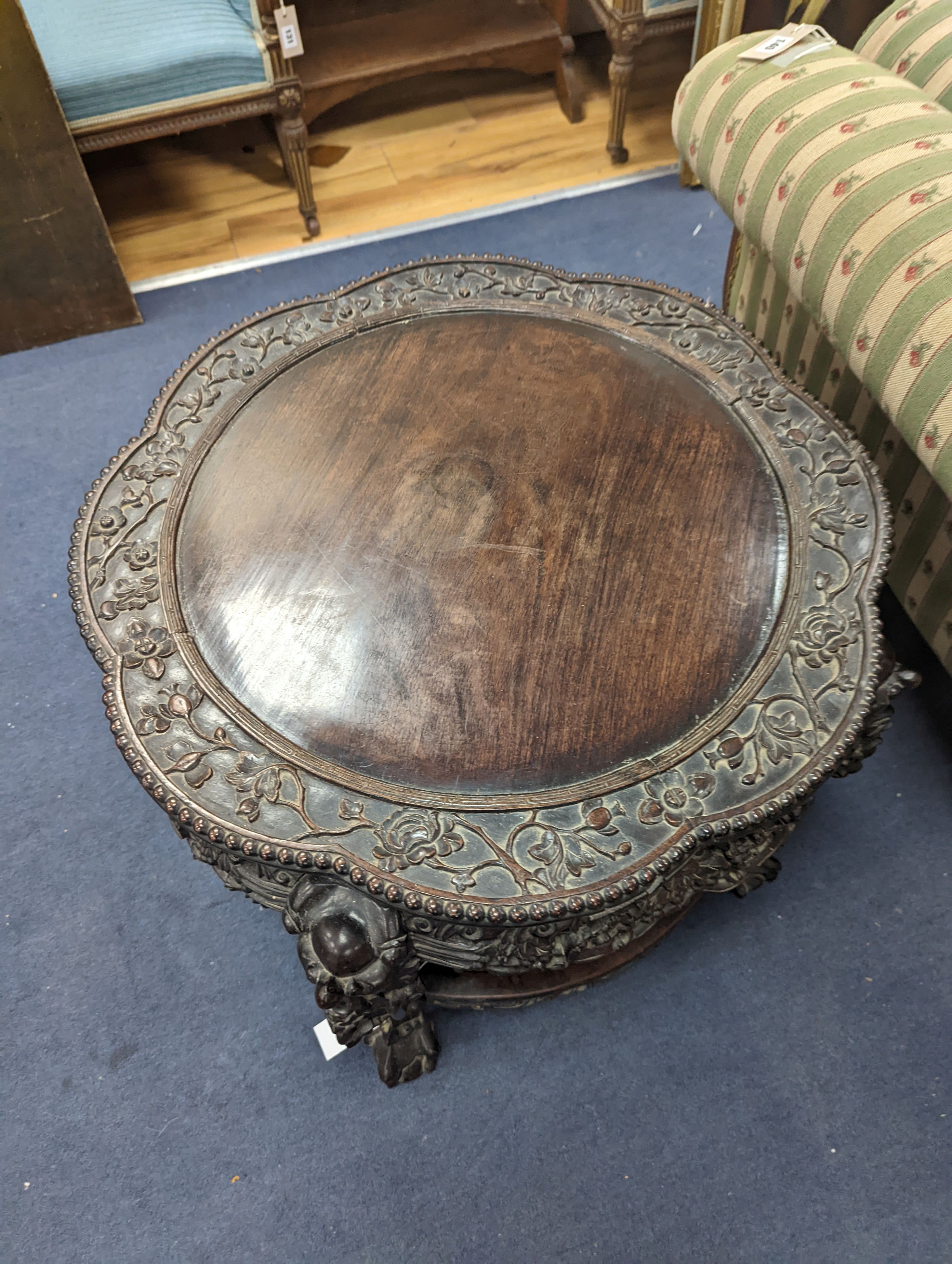 An early 20th century Chinese carved hardwood two tier table, diameter 64cm, height 56cm